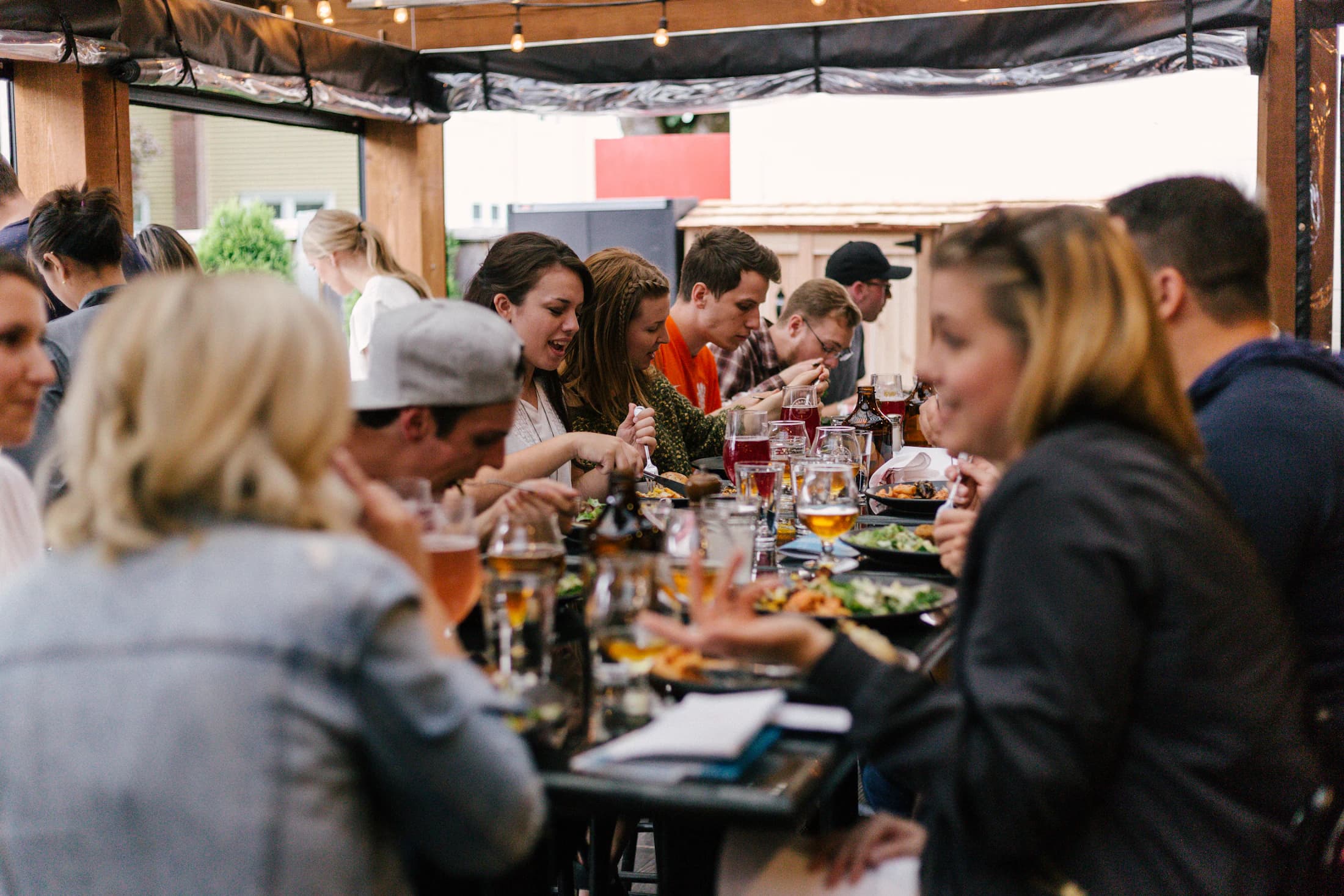 Een lange tafel waar mensen samen eten